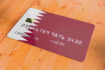 Plastic credit or bank debit card with country flag of Qatar national banking system isolated on wooden table close up concept 3d rendering image