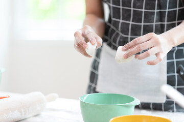 Obraz premium close up chef hands cracking fresh egg yolk and dropping in a bowl