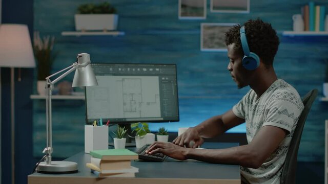 African american engineer designing blueprint plan on computer for construction. Black architect with headphones working on floor layout for building model development. Urban project