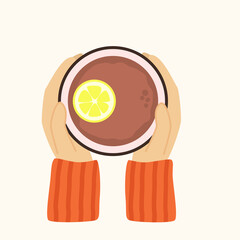 Cup of tea and hands top view. Black tea with lemon. Hands holding cup. The guy warms his hands on a cup of tea. The concept of comfort, warmth of tea drinking.