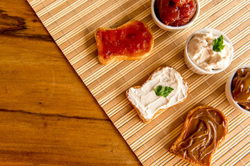 Toasted bread with jam, dulce de leche and ricotta cream on a breakfast table.