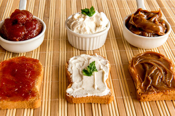 Toasted bread with jam, dulce de leche and ricotta cream on a breakfast table.