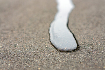 Water flows on dry asphalt in the direction of the chamber.