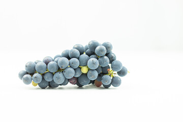bunch of blue grapes on a white background. Harvest of wine berries on the table. Side view photo