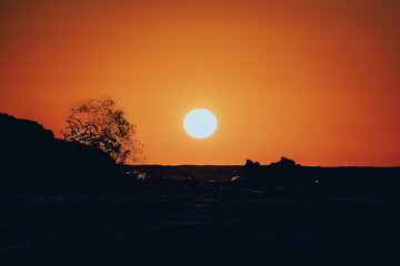 Sonnenuntergang über dem Meer mit brechenden Wellen