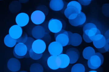 Defocused lights. Blue bokeh on black background. Christmas and New year overlay. Copy space