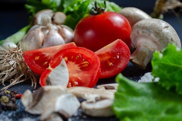 Fresh sliced tomato on a table with garlic and herbs