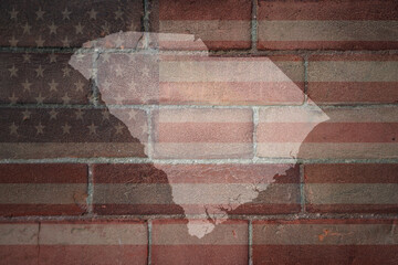 map of south carolina state on a painted flag of united states of america on a brick wall