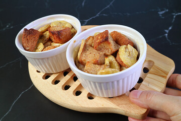 Hand Holding a Breadboard of Fresh Baked Delectable Banana Bread Pudding Bowls