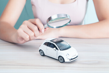 woman with a magnifying glass looks at the car. car search concept