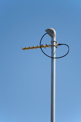 UHF radio antenna on pole against blue sky portrait format