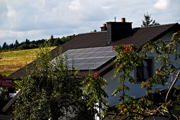 Panele słoneczne ( solarny) na dachu domu wśród wzgórz . Solar panels (solar) on the roof of...