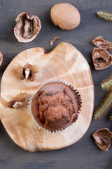  freshly baked golden cupcake with walnuts on a wooden serving board on a brown background. cracked walnuts. top view. a place to copy. The concept of nutrition. sweet homemade cakes. flat lay