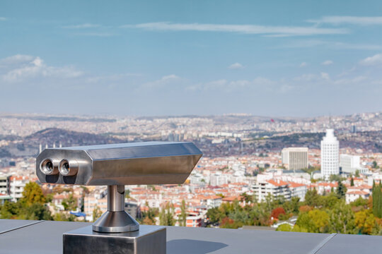 Coin operated binocular viewer at the terrace floor of Atakule in front of blurry Ankara view.