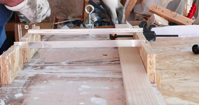 Hobbysta using hand held worm drive circular saw to cut boards on a new handcrafted product in wood