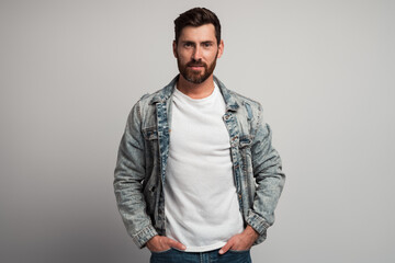 Fototapeta premium Portrait of attentive self confident bearded man looking at camera with serious expression. Smiling determined business man. Indoor studio shot isolated on white background