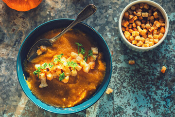 Fresh homemade pumpkin soup served with croutons, top view