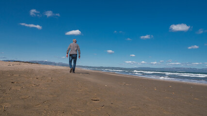 Senior man walking on the beach in winter