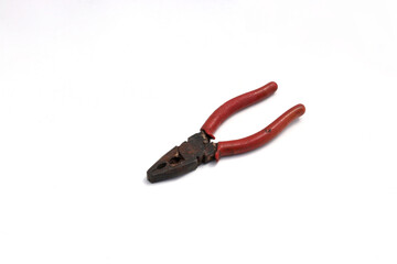 Old used rusty pliers with red grip isolated on white background.