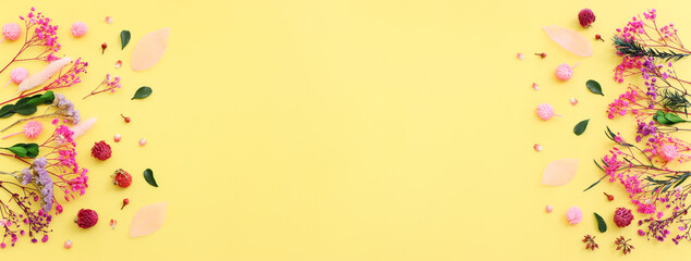 Top view image of pink, purple and green flowers composition over pastel yellow background .Flat lay