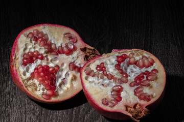 Two halfs of Ripe Pomegranate on a Dark Background,