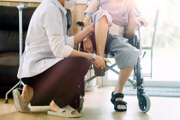 young asian physical therapist working with senior woman on walking with a walker