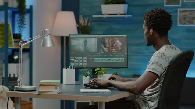 Man working as videographer editing video with musical footage for freelance project. Film maker doing retouch work with visual effects on computer for montage production. Content creator