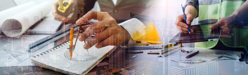 Two colleagues discussing data working and tablet, laptop with on on architectural project at construction site at desk in office