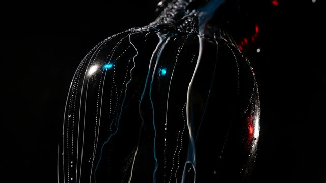 close-up of a female ass in a black latex suit on a dark background. white liquid pours over it