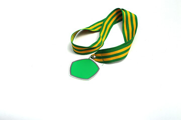Naklejka premium Graduation medal with the empty green pentagon-shaped medal and green-yellow stripes ribbon isolated on white background. Education, sport, champion, winners concept background stock images.
