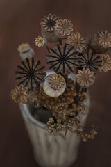 Dry Poppy seed Heads. Bouquet of field dried flowers. Vintage toned image. Selective focus. Dry flowers in vintage natural tone, background texture. Vertical image