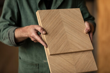 Checking pieces of wood, MDF with wooden veneer material in a woodworking workshop with a designer...