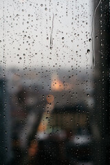 Closeup of rain on window with city outside