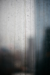 Closeup of rain drops on a window and gray skies outside