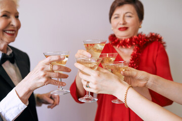 new year celebrating hands with glasses of white sparkling wine. Christmas, family, friends, celebrating, new year concept