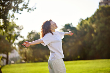 A ginger long-haired girl spending time in a park feeling happy