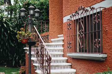 Fototapeta Beautiful orange brick house with a white outdoor staircase obraz
