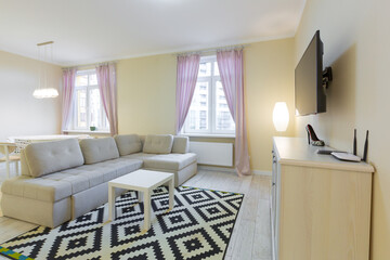 living room interior, with large sofa and TV, with purple curtains, modern style in light colors