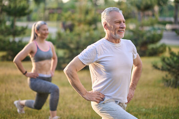 Two sportive mature adults exercising in the park