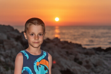 A nice boy on the beach at sunset