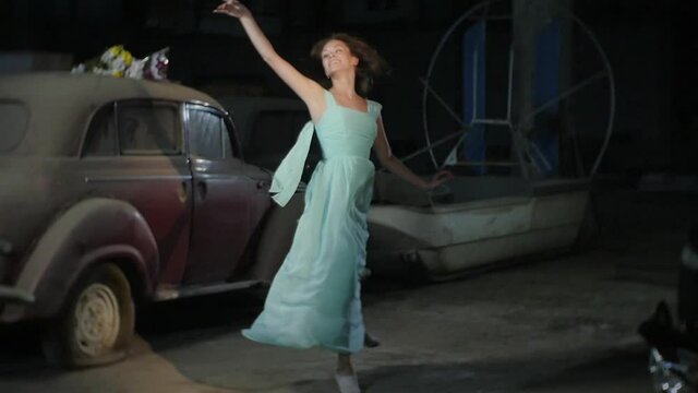 Girl in a Beautiful Dress is Dancing Around an Old Car
