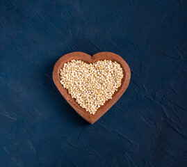 Chenopodium quinoa - Organic white quinoa seeds in heart shaped bowl