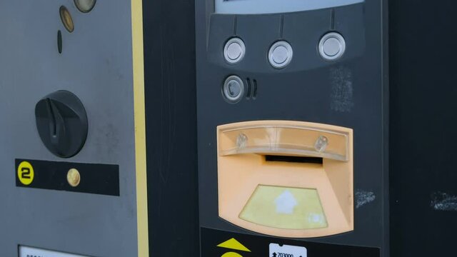 Young woman while pay car parking to an automated parking meter machine