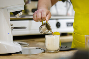 Barista making latte macchiato with rich froth at cafe - obrazy, fototapety, plakaty