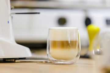 Latte macchiato with rich froth in beautiful glass at cafe