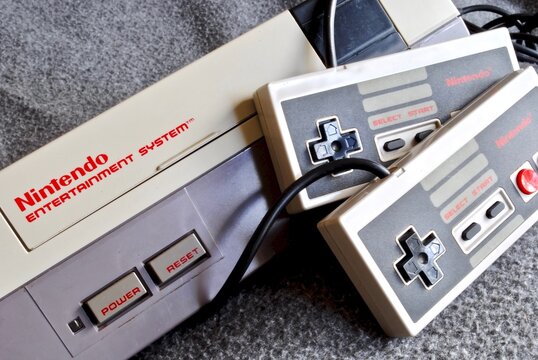The Nintendo Entertainment System (NES), an 8-bit third-generation home video game console produced by Nintendo. NES Control Deck home video game console with controllers.