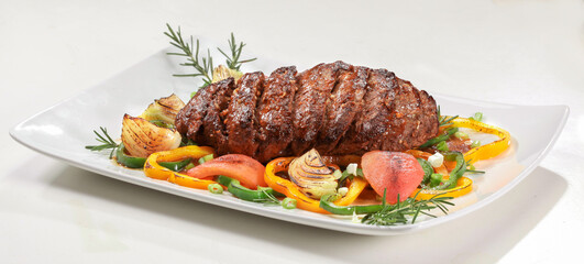 Carne assada fatiada na travessa com legumes. 