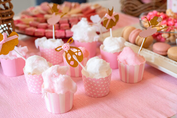 Pink paper cups filled with cotton candy for kid's birthday party