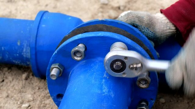 Workers installing water supply pipeline system, close up