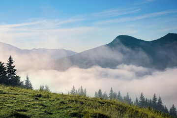 Beautiful view of mountains covered with fog at sunrise